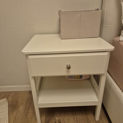 שידת לילה לבנה עם מגירה על רצפת עץ