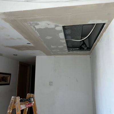 תיקון גבס בתקרה עם סולם וחוטי חשמל