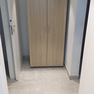 ארון עץ עם ידיות מתכת בחדר קטן