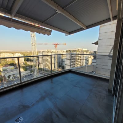 מרפסת נקייה עם רצפה כהה ונוף עירוני