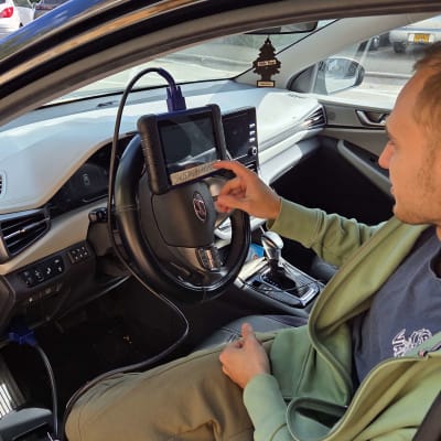 אדם עובד עם מכשיר אבחון ברכב