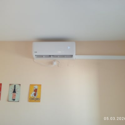 מזגן מותקן על קיר עם שלושה פוסטרים קטנים