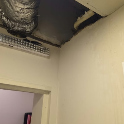 חשיפת תעלות וצינורות של מזגן מיני מרכזי בתקרת גבס לצורך תיקון