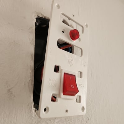 מתג חשמלי עם כפתור אדום בקיר