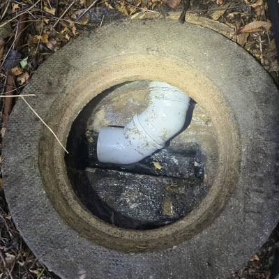 צינור ביוב בתוך פתח עגול באדמה