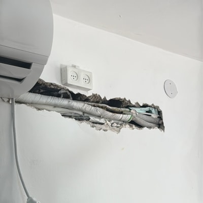 מזגן מותקן על קיר עם חיווט חשוף