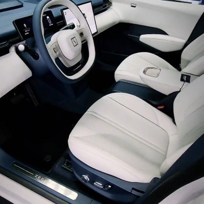 פנים רכב עם מושבים לבנים והגה מודרני