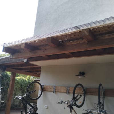 פרגולה מעץ עם אופניים תלויים על הקיר