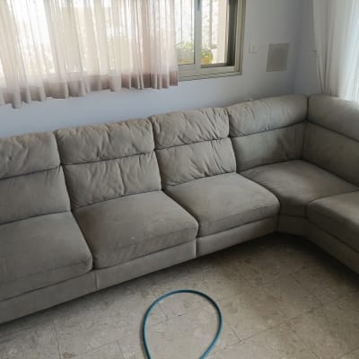 ספה אפורה עם כתמים קלים בחדר מגורים