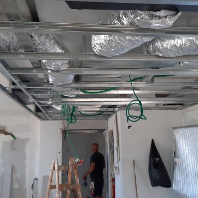 תקרת מתכת עם צינורות ירוקים וכסופים במהלך שיפוץ