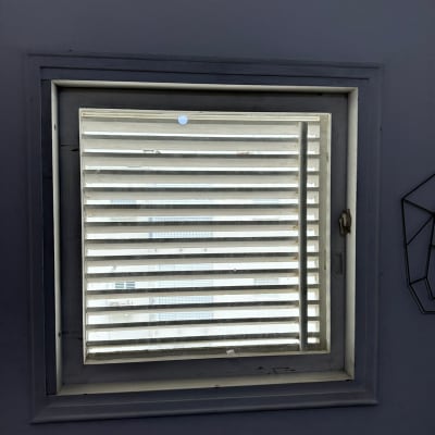 חלון עם תריסים סגורים וידית בצד ימין