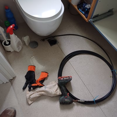 כלי עבודה של אינסטלטור ליד אסלה בחדר אמבטיה