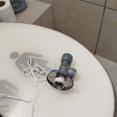 ברז מתכת עם חוטי איטום על מכסה אסלה