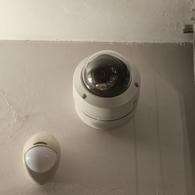 מצלמת אבטחה עגולה על תקרה לבנה
