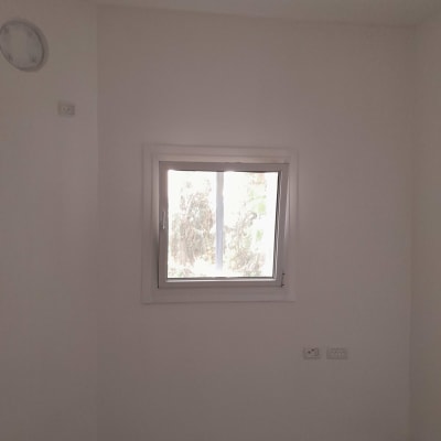 חלון קטן בקיר לבן עם שקעי חשמל