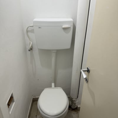 אסלה ומיכל הדחה בחדר שירותים קטן