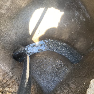 צינור בתוך בור עם מים, קשור למשאית ואקום