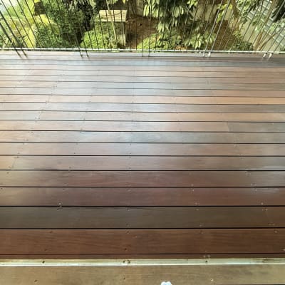 דק עץ חום עם מעקה מתכת בגינה