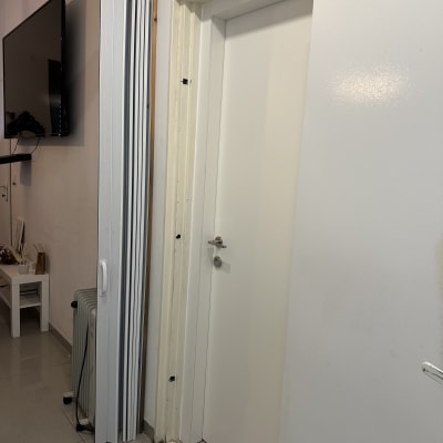 דלת לבנה עם ידית כסופה ומסגרת עץ