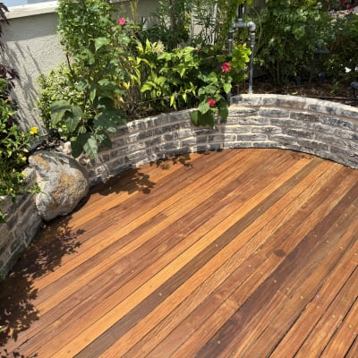 דק עץ עם צמחים ופרחים מסביב