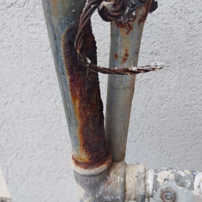 צינור חלוד עם חיבורי מתכת וחבל קשור