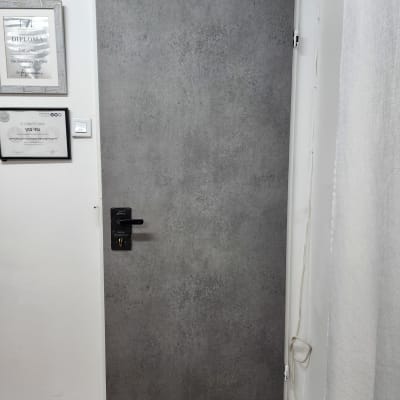 דלת מצופה עם ידית שחורה ותעודות על הקיר