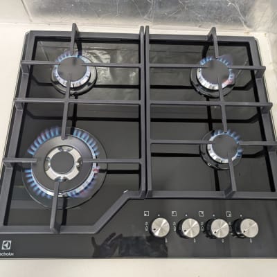 כיריים גז עם ארבעה מבערים דולקים ומתגים