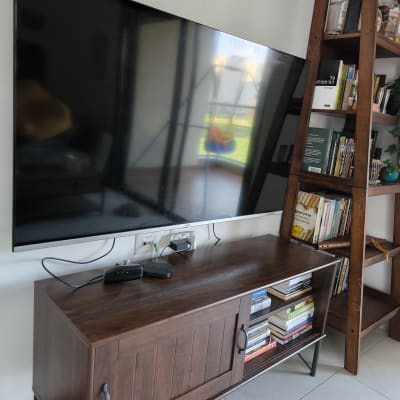 טלוויזיה על קיר עם מדף ספרים וארון עץ