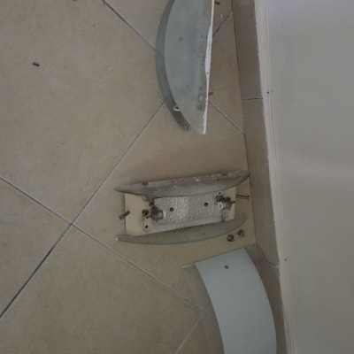 חלקי מנורת קיר מפורקת על רצפה