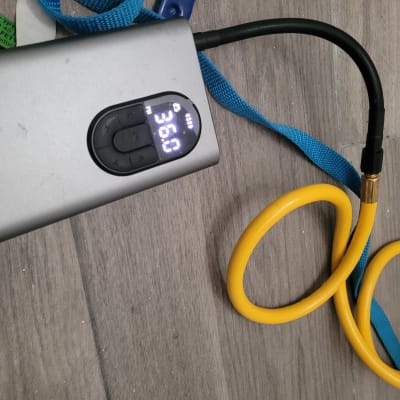 מד לחץ דיגיטלי עם צינור צהוב על רצפה אפורה