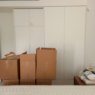 ארגזי קרטון מסומנים ליד ארון לבן