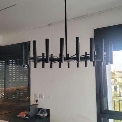 נברשת שחורה תלויה מהתקרה עם חוט חשמל