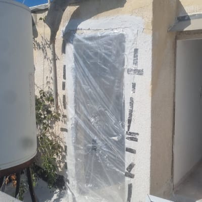 דלת מכוסה בניילון שקוף עם סרטי הדבקה שחורים