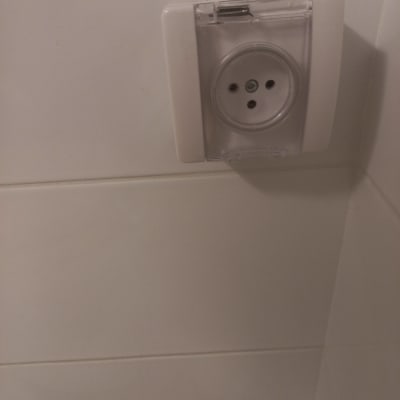 שקע חשמל עם כיסוי שקוף על קיר לבן