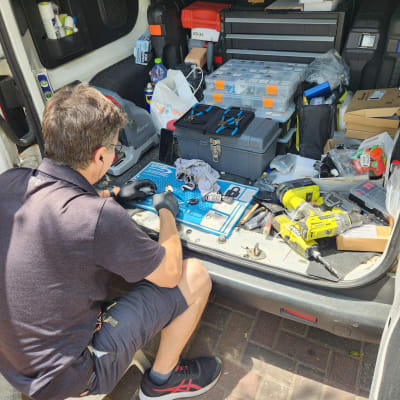 מנעולן רכב עובד עם כלים בתא מטען פתוח