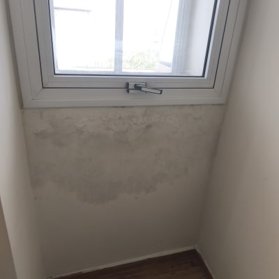 קיר עם סימני רטיבות מתחת לחלון