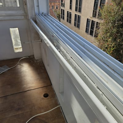 תריסים לבנים פתוחים ליד חלון זכוכית