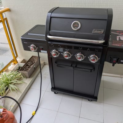 גריל גז שחור על מרפסת עם צמחייה וגז.