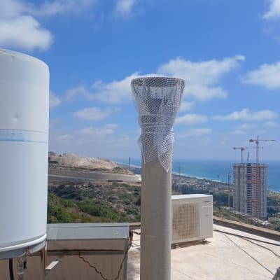 גג עם מזגנים ונוף לים ולבניינים