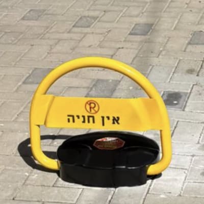 מחסום חניה צהוב על מדרכה