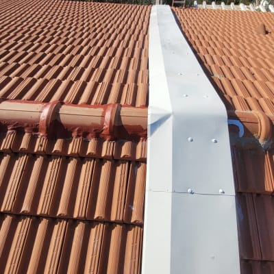 גג רעפים חום עם כיסוי מתכת לבן במרכז