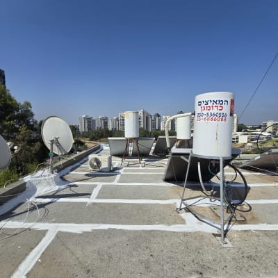 איטום גג עם חומר לבן בין אריחים