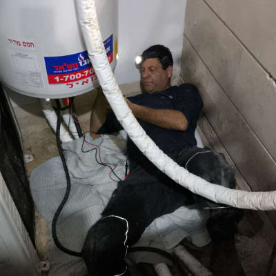 אדם מתקן דוד שמש עם פנס ראש