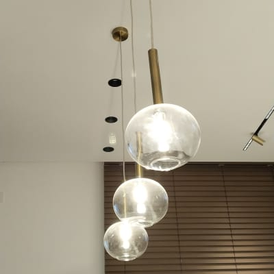 שלושה גופי תאורה תלויים עם נורות דולקות