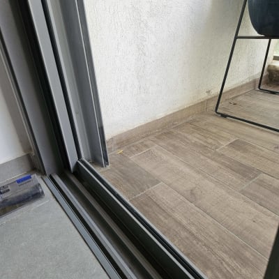 דלת זכוכית עם מסגרת מתכת על רצפת עץ