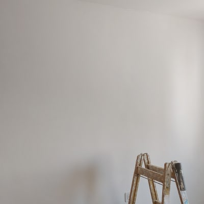 סולם עץ ליד קיר צבוע בלבן