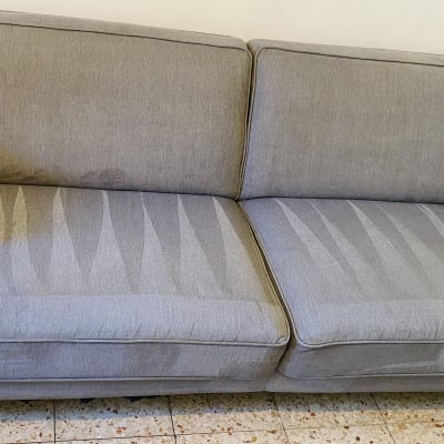 ספה אפורה עם כתמי ניקוי נראים על המושב