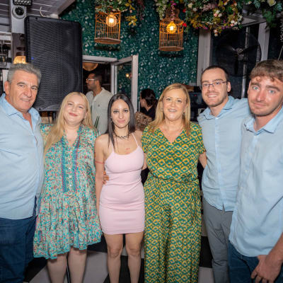 קבוצה של אנשים מצולמת במסיבה עם תאורה צבעונית