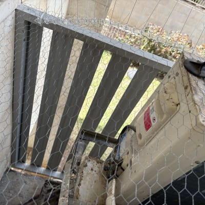 יחידת מזגן חיצונית עם רשת הגנה על מרפסת