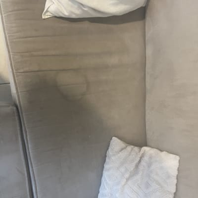 כתמים על ספה בהירה עם כריות לבנות